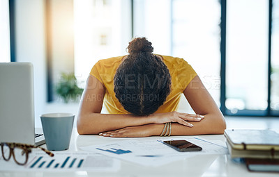 Buy stock photo Shot of a young designer with her head down on her office desk