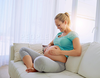 Buy stock photo Shot of a pregnant woman holding her belly at home