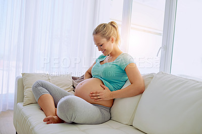 Buy stock photo Pregnancy, smile and woman on sofa in home holding belly for maternity care with happiness. Love, relaxing and maternal female person from Australia touch stomach in living room at apartment.