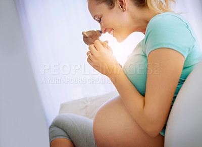 Buy stock photo Shot of a pregnant woman holding a teddy bear while relaxing at home