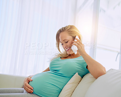 Buy stock photo Shot of a pregnant woman talking on a cellphone at home