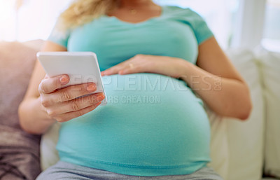 Buy stock photo Closeup shot of a pregnant woman texting on her cellphone at home