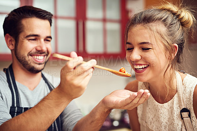 Buy stock photo Food, man feeding a woman with spoon and in a kitchen of their home. Hungry or happiness, healthy relationship and happy people cooking preparing meal for lunch or dinner time in their house