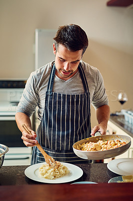 Buy stock photo Shot of a young man cooking in the kitchen