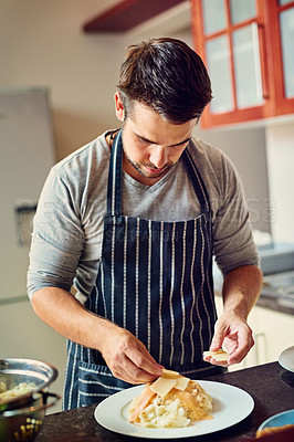 Buy stock photo Shot of a young man preparing food in the kitchen at home