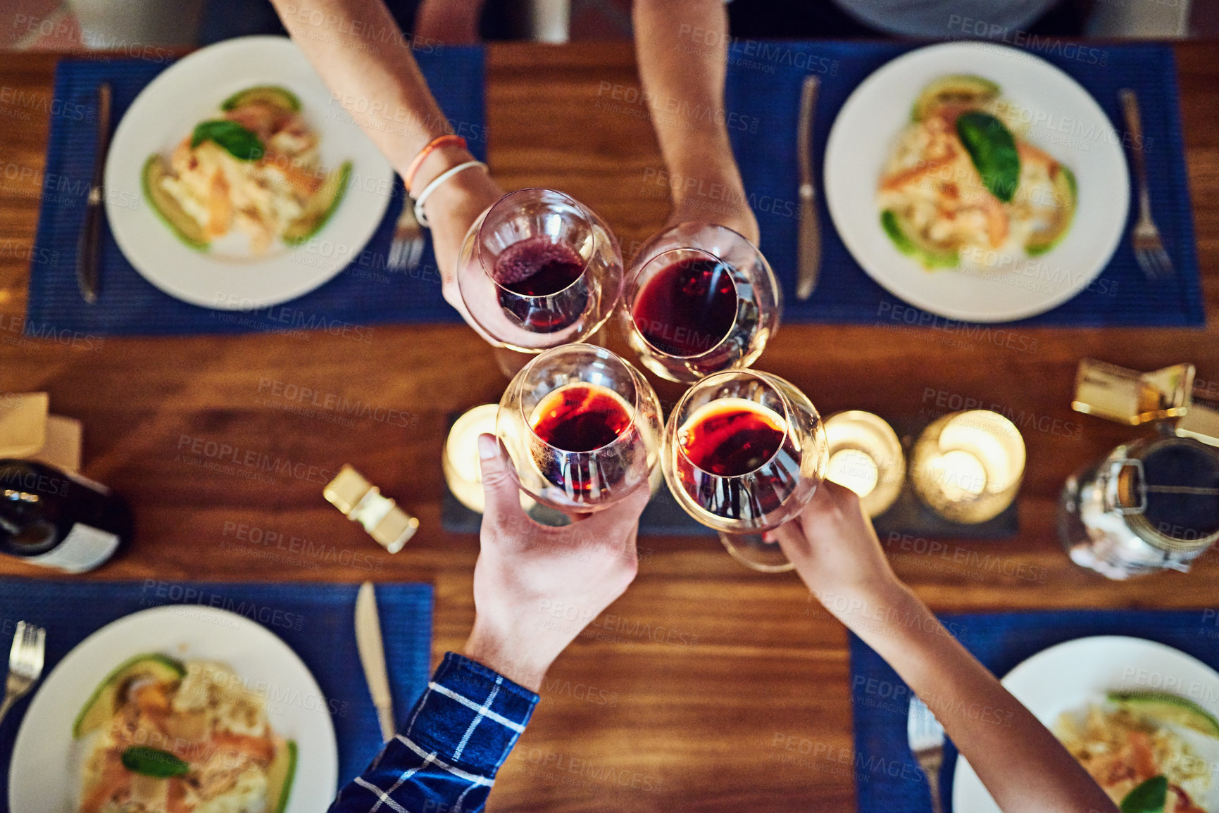 Buy stock photo Shot of a group of unrecognizable people toasting at the dining room table at home