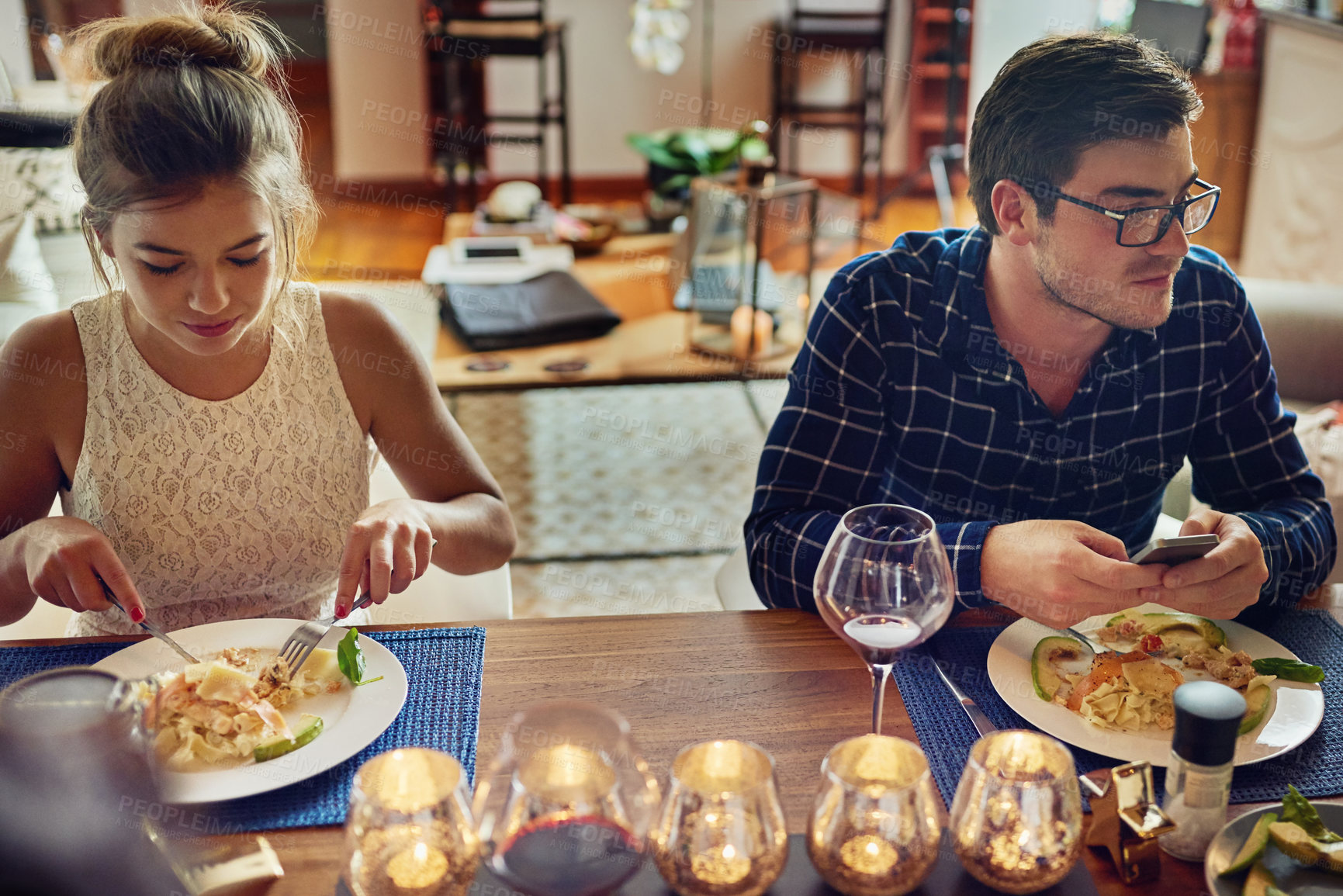 Buy stock photo Shot of young couple enjoying a meal at the table