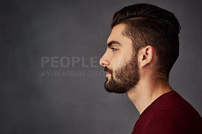 Buy stock photo Studio shot of a handsome young man posing against a dark background