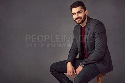 Buy stock photo Studio portrait of a handsome young man posing against a dark background