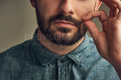 Buy stock photo Man, face and twirl mustache in studio for grooming, haircare and styling on dark background. Male barber, hand and fingers pulling hair for aesthetic, growth and beard maintenance or preparation