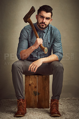 Buy stock photo Studio shot of a young man posing with an axe against a green background