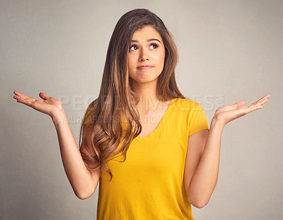 Buy stock photo Thinking, doubt and shrug with a woman in studio on a gray background looking confused by her options. Idea, question and hand gesture with an attractive young female person weighing up a decision