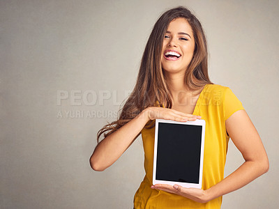 Buy stock photo Shot of an attractive young woman holding a digital tablet with a blank screen against a grey background