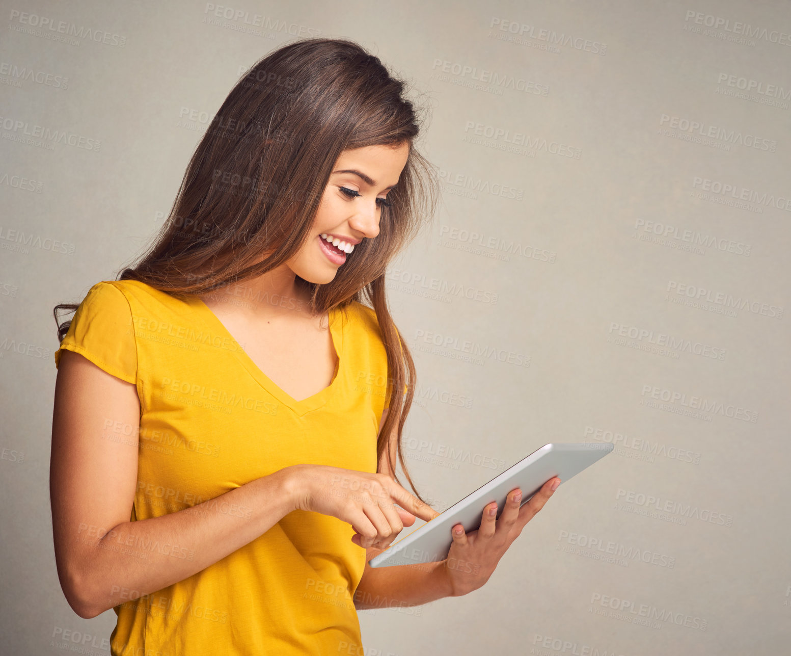 Buy stock photo Woman, happy and browse tablet in studio background for social media, networking and communication. Female person, smile and satisfied with good news, streaming platform and website fro entertainment