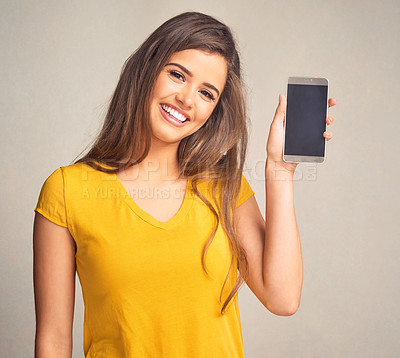 Buy stock photo Portrait, woman and display of cellphone in studio with mockup space for advertising, marketing or promotion. Smile, technology and female person presenting phone screen isolated by gray background