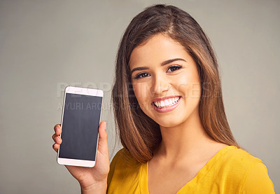 Buy stock photo Happy, woman and display of phone in studio with mockup space for advertising, marketing or promotion. Portrait, technology and female person presenting cellphone screen isolated by gray background.