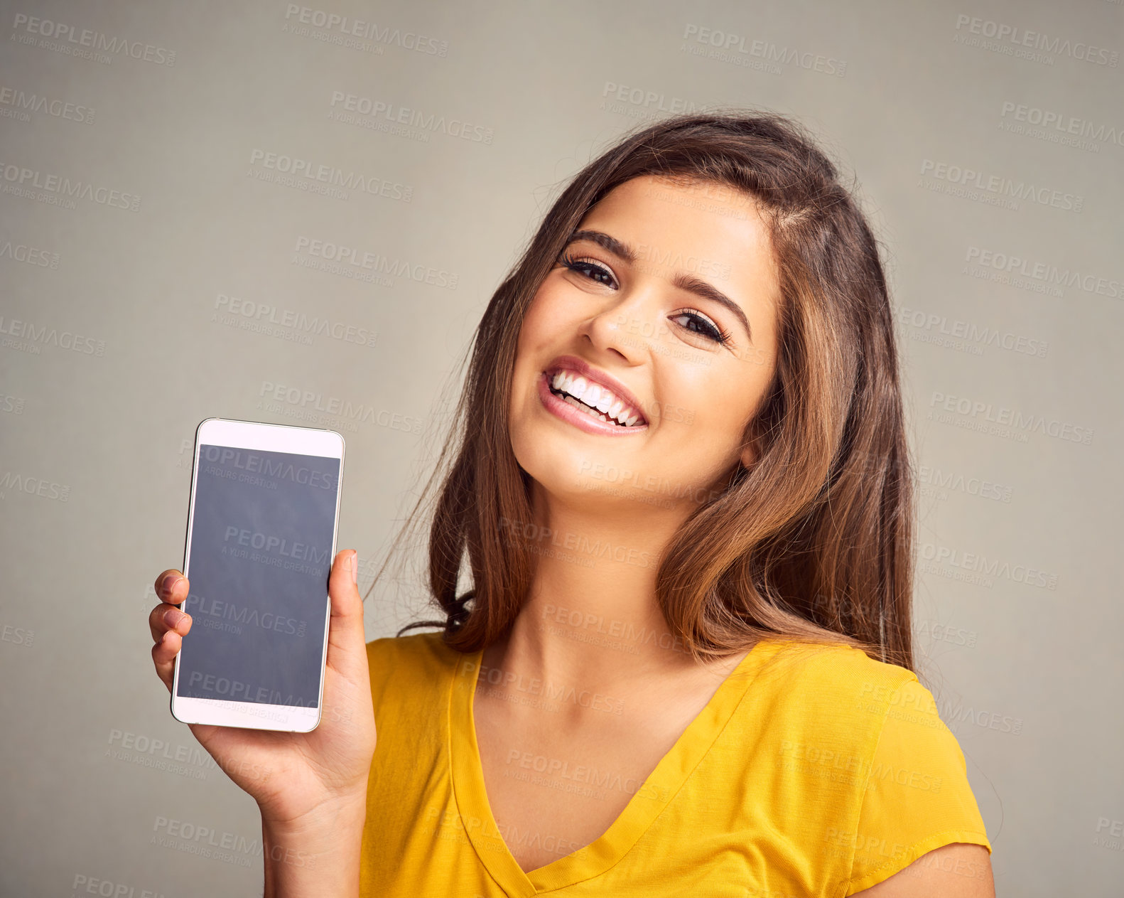 Buy stock photo Smile, woman and display of phone screen in studio with mockup space for advertising, marketing or promotion. Portrait, technology and female person presenting cellphone isolated by gray background.