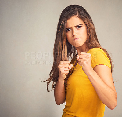 Buy stock photo Studio shot of an attractive woman putting up her firsts against a grey background