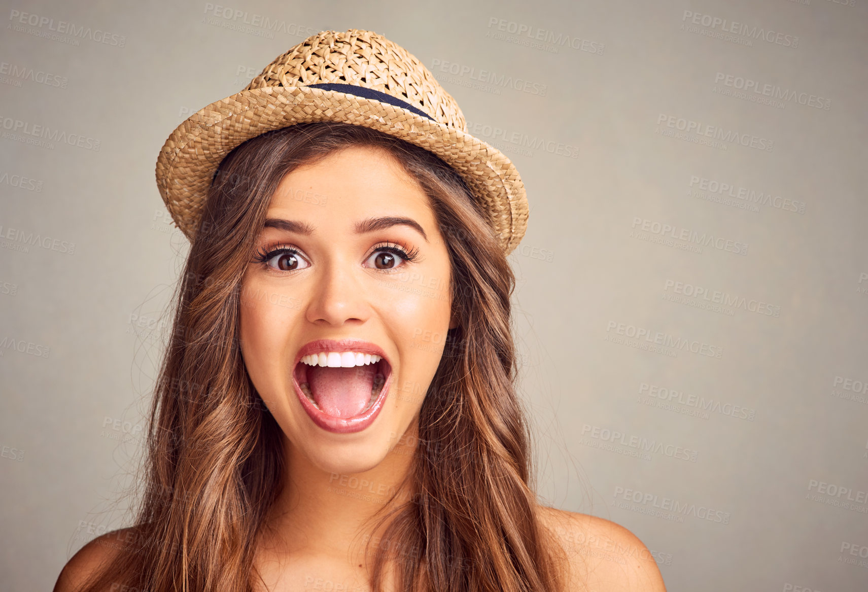Buy stock photo Studio portrait of an attractive young woman looking excited against a gray background