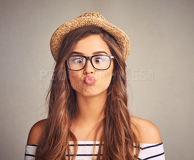 Buy stock photo Studio shot of an attractive young woman making a funny face against a gray background