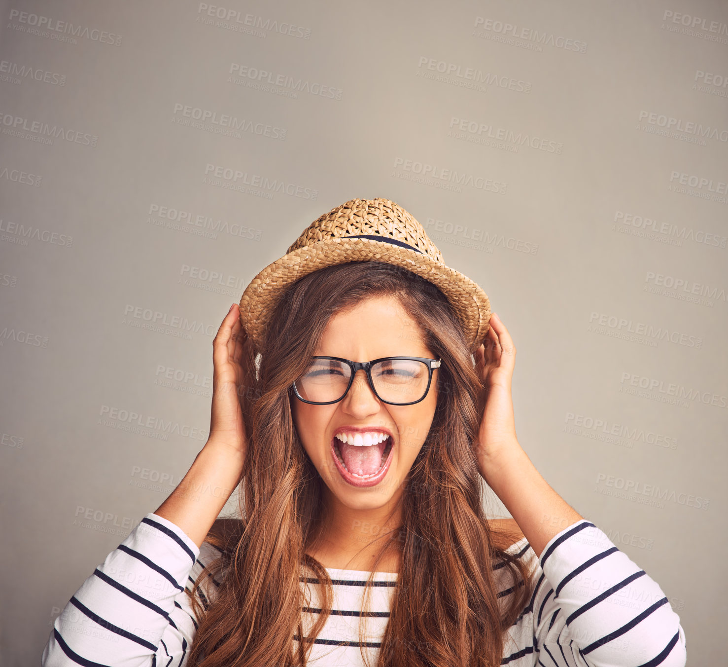 Buy stock photo Studio portrait of an attractive young woman screaming against a gray background