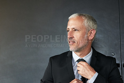 Buy stock photo Cropped shot of a handsome mature businessman standing in the office while looking outside a window