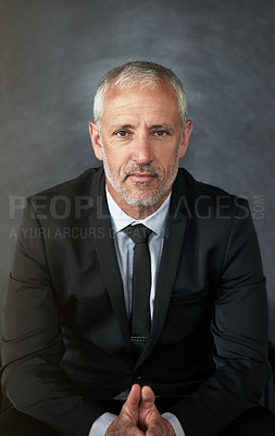 Buy stock photo Cropped shot of a handsome mature businessman seated in the office with his hands together