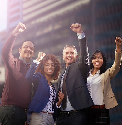 Buy stock photo Shot of a motivated business team putting their hands up for success while standing outside