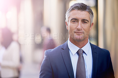 Buy stock photo Shot of a mature businessman standing and looking confident outside in the streets