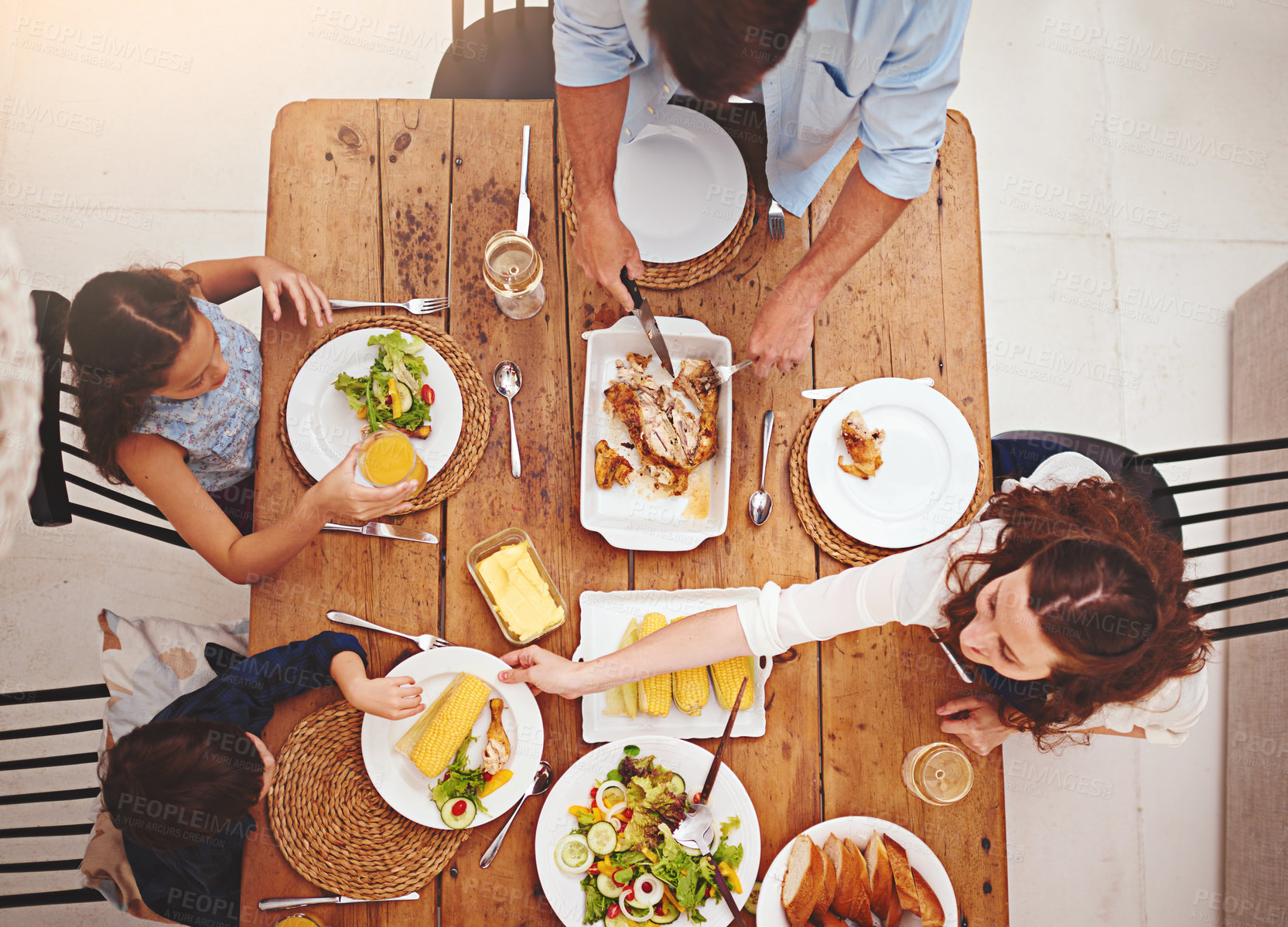 Buy stock photo High angle shot of a family eating  homemade food around the dining room table