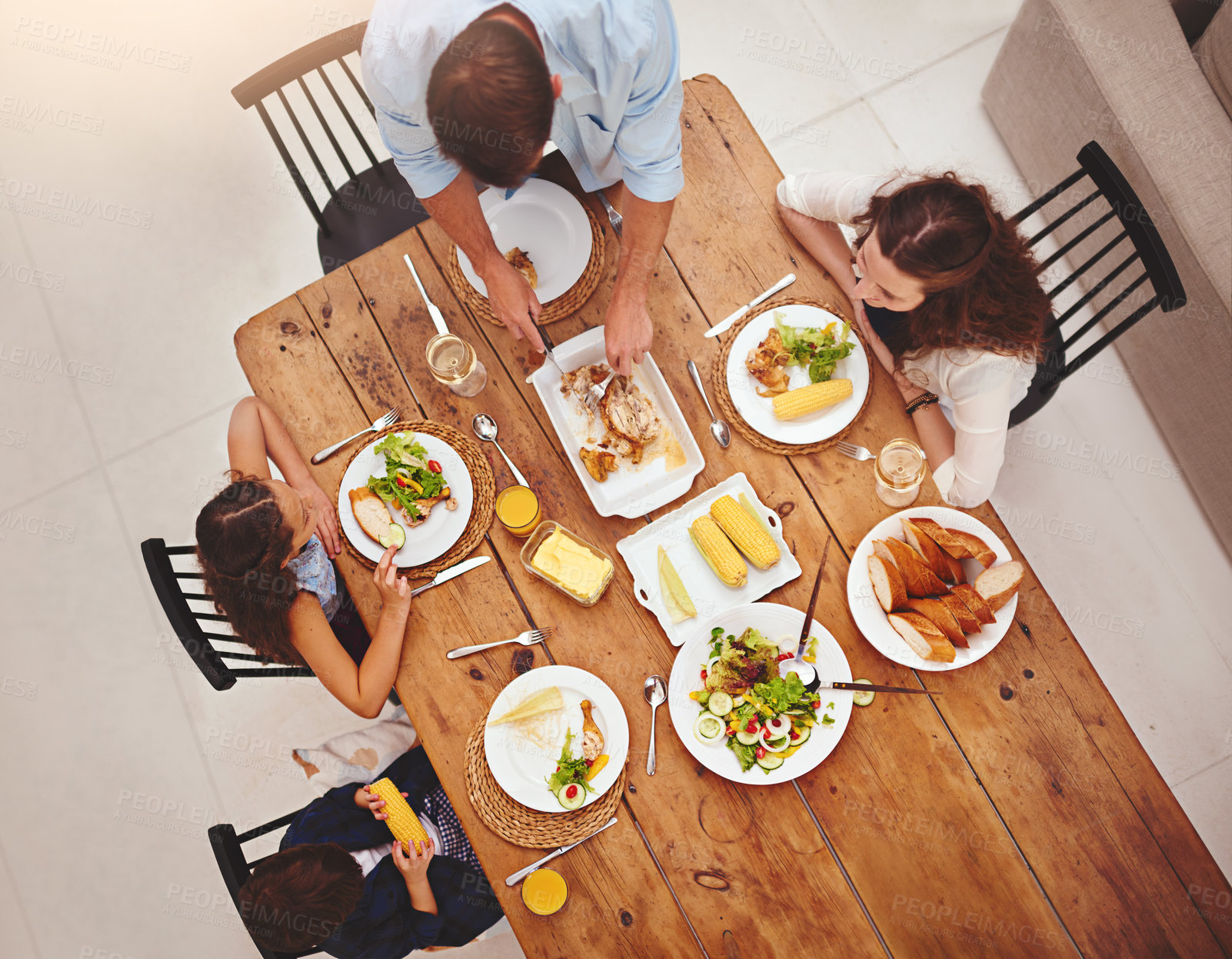 Buy stock photo High angle shot of a family eating  homemade food around the dining room table