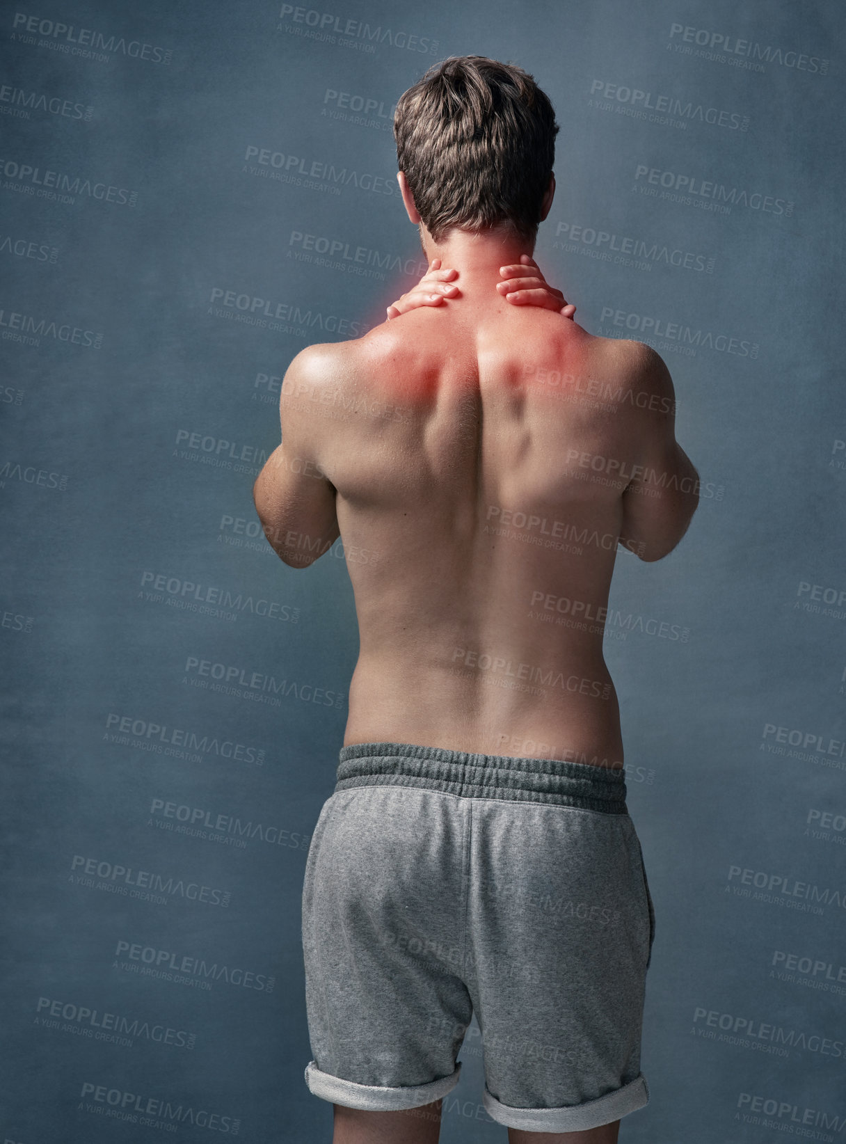 Buy stock photo Rearview shot of an unidentifiable young man with cgi indicating inflammation in his shoulders in studio