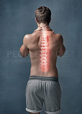 Buy stock photo Rearview shot of an unidentifiable young man with cgi indicating inflammation in his back in studio