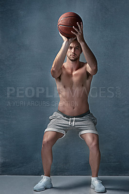 Buy stock photo Portrait of a focussed young man aiming before throwing a basketball in studio