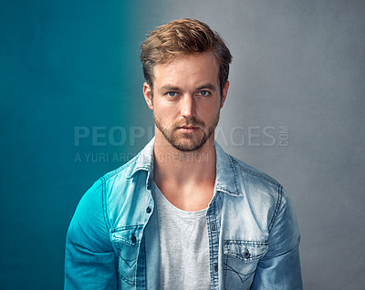 Buy stock photo Portrait of a handsome young man with a blue overlay posing against a gray background in the studio