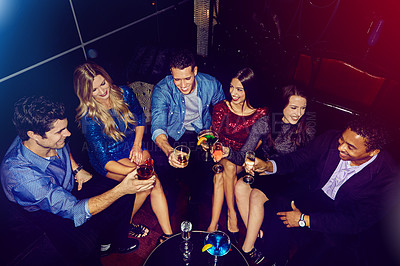 Buy stock photo Shot of a group of friends toasting with drinks at a party