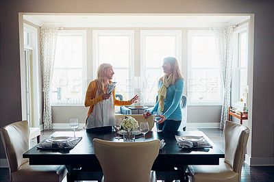 Buy stock photo Shot of two women setting up the dining room table