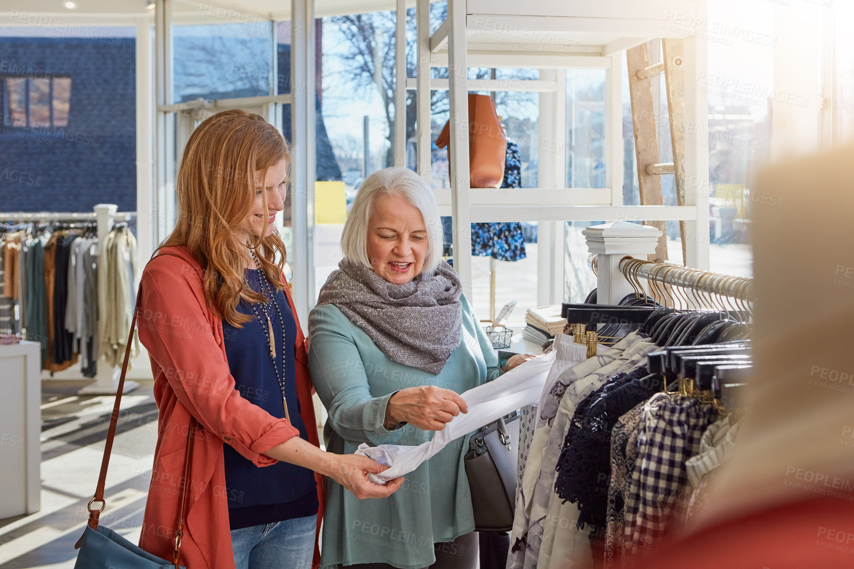 Buy stock photo Shot of a mother and daughter shopping in a clothing store