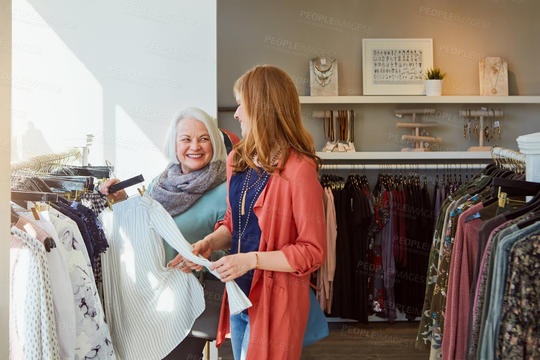 Buy stock photo Shot of a mother and daughter shopping in a clothing store