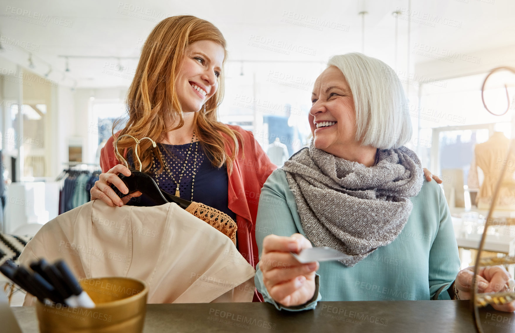 Buy stock photo Shot of a mother and daughter shopping in a clothing boutique