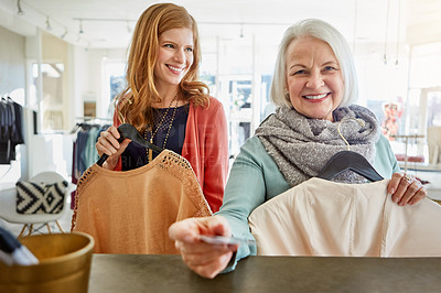 Buy stock photo Shot of two women standing at a checkout counter in a clothing store