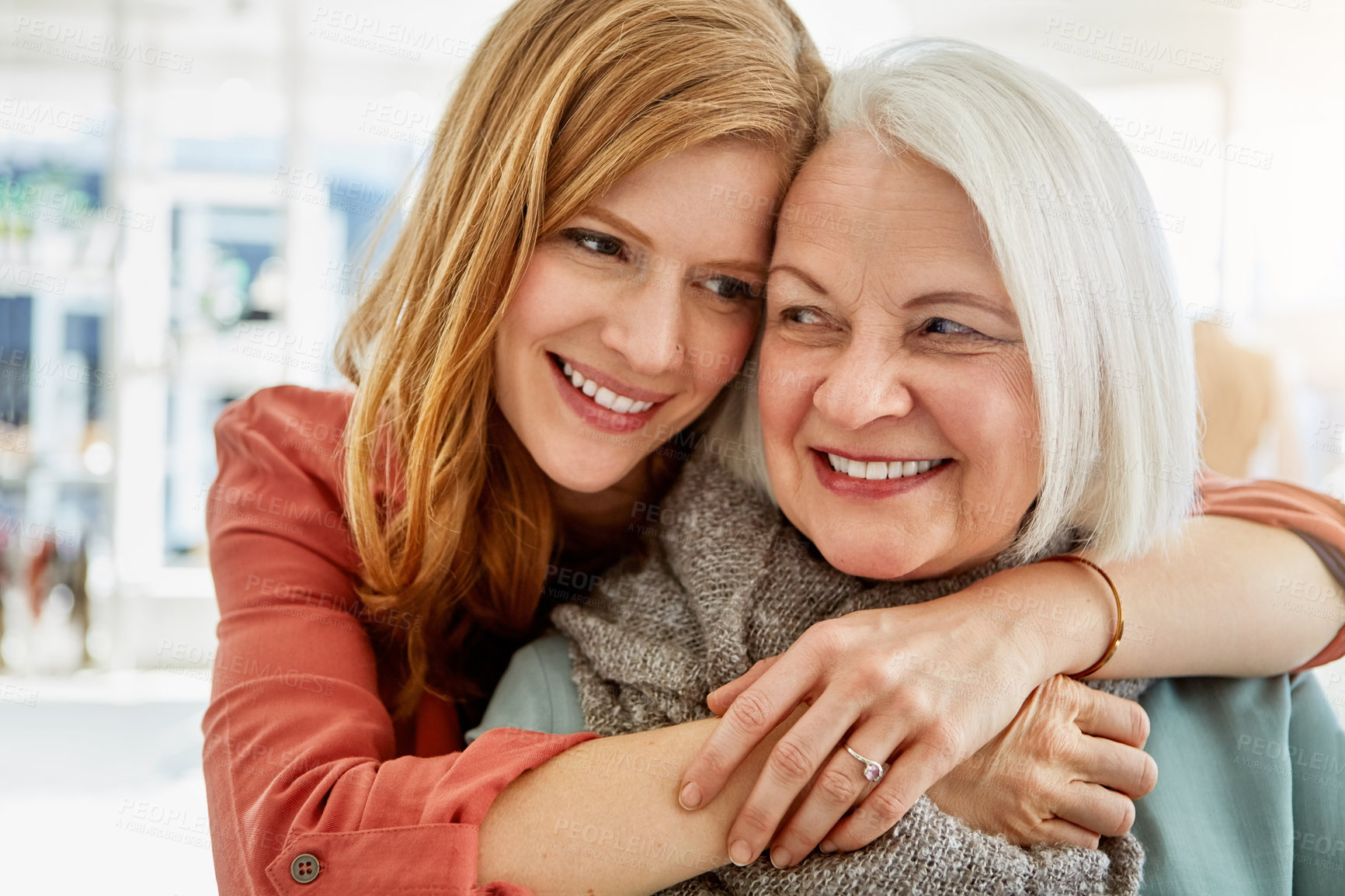 Buy stock photo Shot of a happy young woman standing behind her senior mother