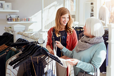 Buy stock photo Shot of a mother and daughter shopping in a clothing boutique