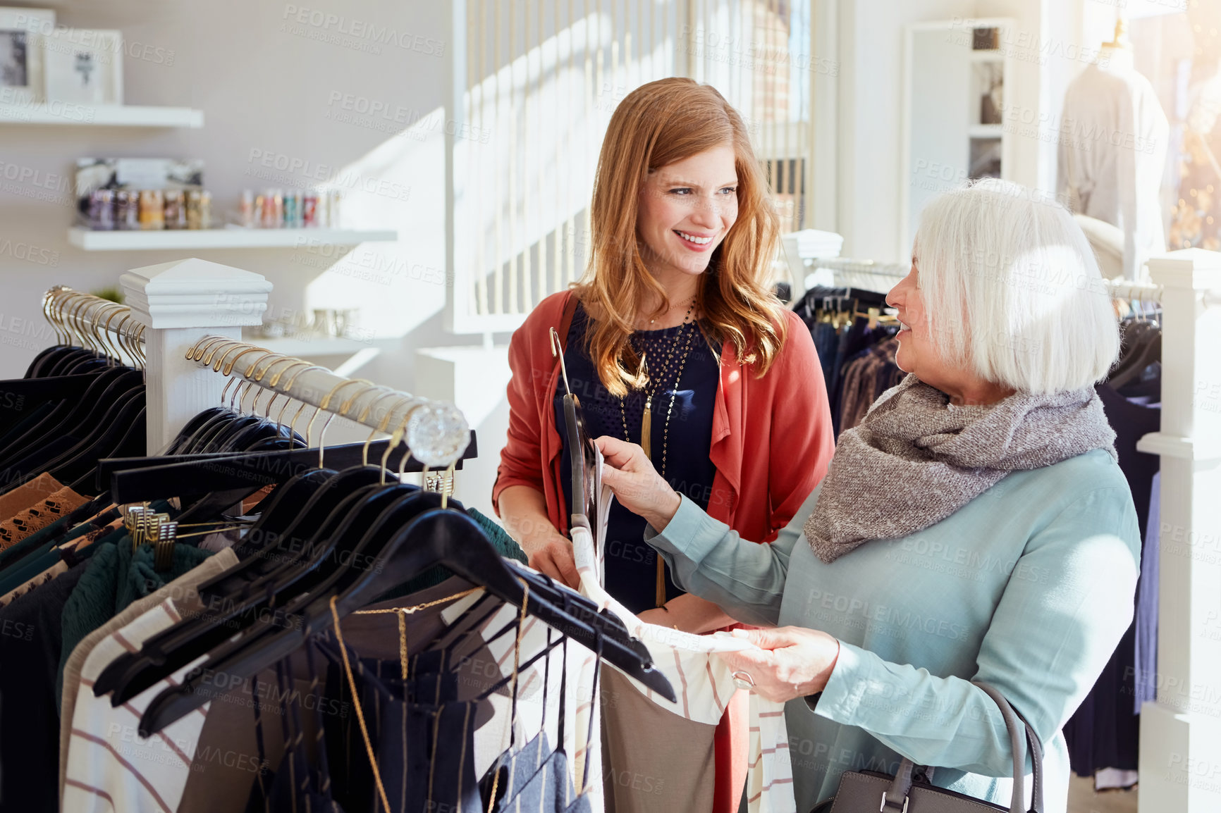 Buy stock photo Shot of a mother and daughter shopping in a clothing boutique