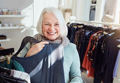 Buy stock photo Shot of a senior woman shopping in a clothing boutique