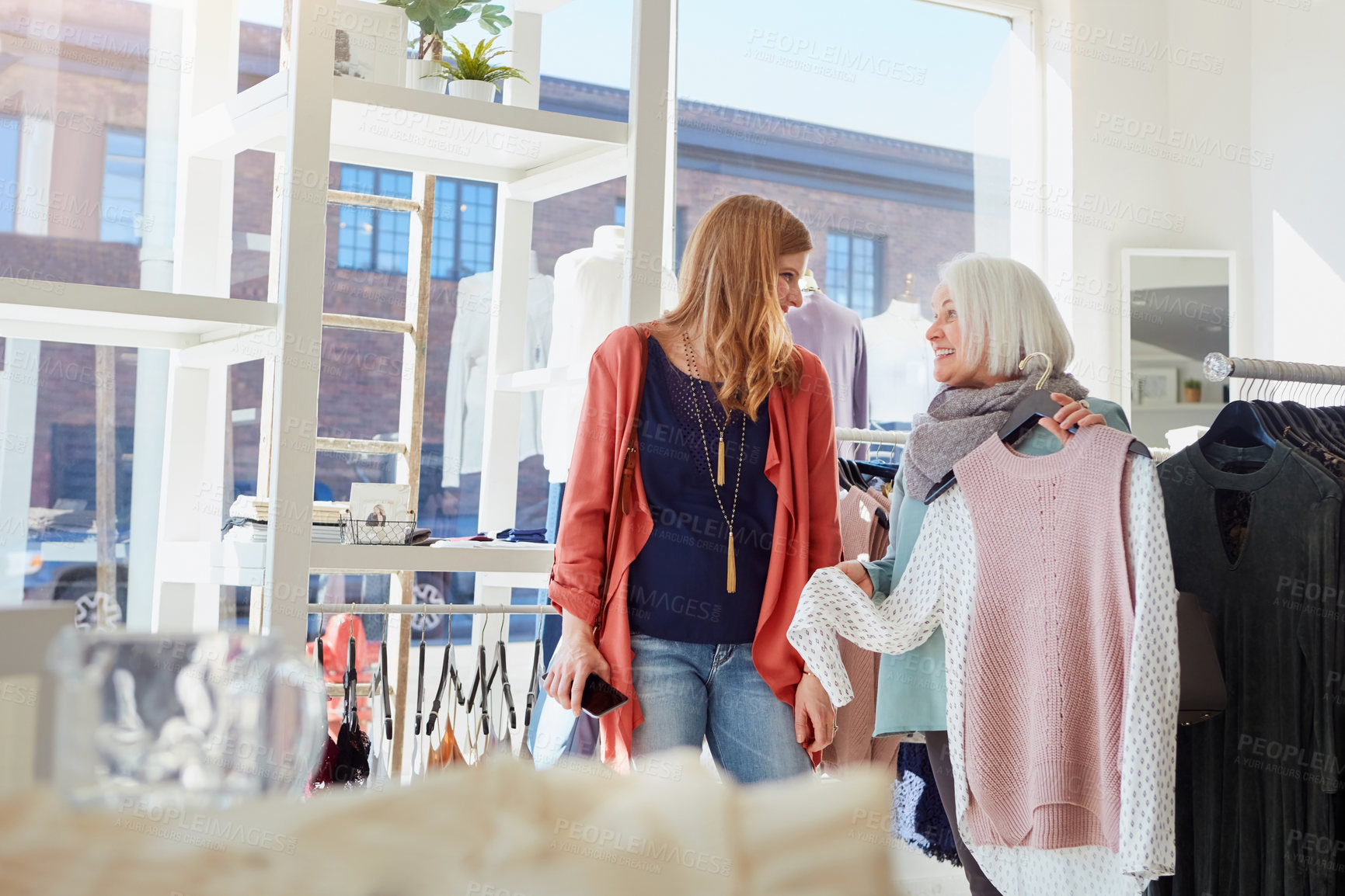 Buy stock photo Senior mom, woman and shopping at boutique with choice for clothes, smile and conversation at mall. People, elderly mother and adult daughter with fashion, sale and happy for discount at retail store