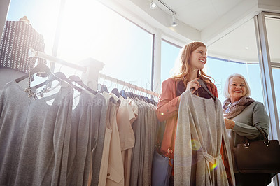 Buy stock photo Shot of a mother and daughter shopping in a clothing boutique
