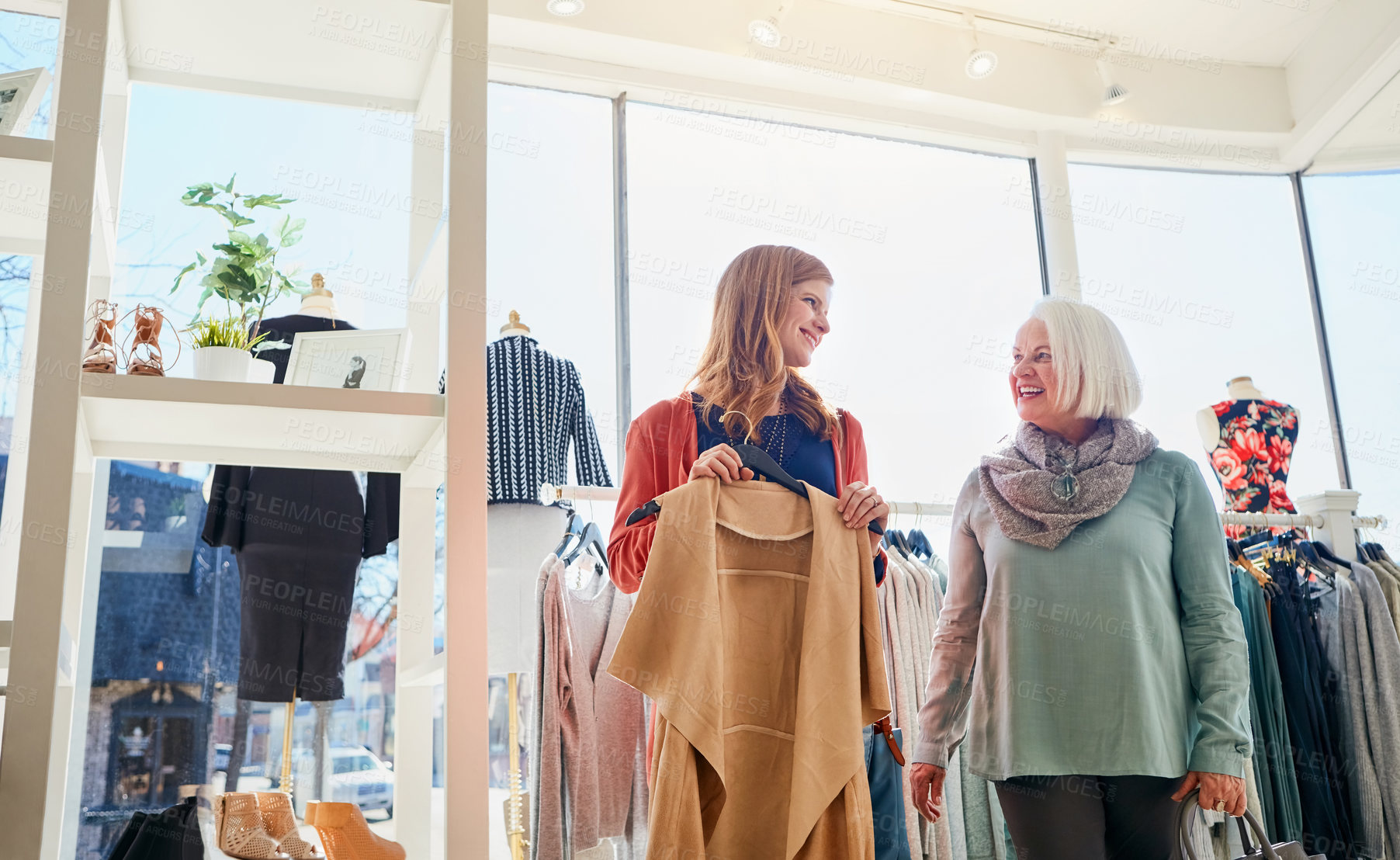 Buy stock photo Shot of a mother and daughter shopping in a clothing boutique