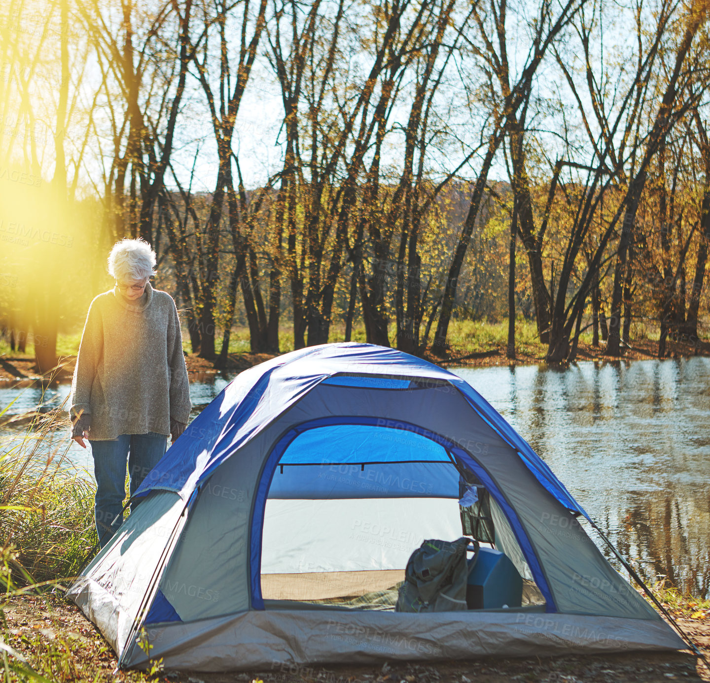 Buy stock photo Shot of a senior woman camping in the wilderness