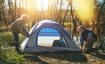 Buy stock photo Shot of a senior couple setting up a tent while camping in the wilderness